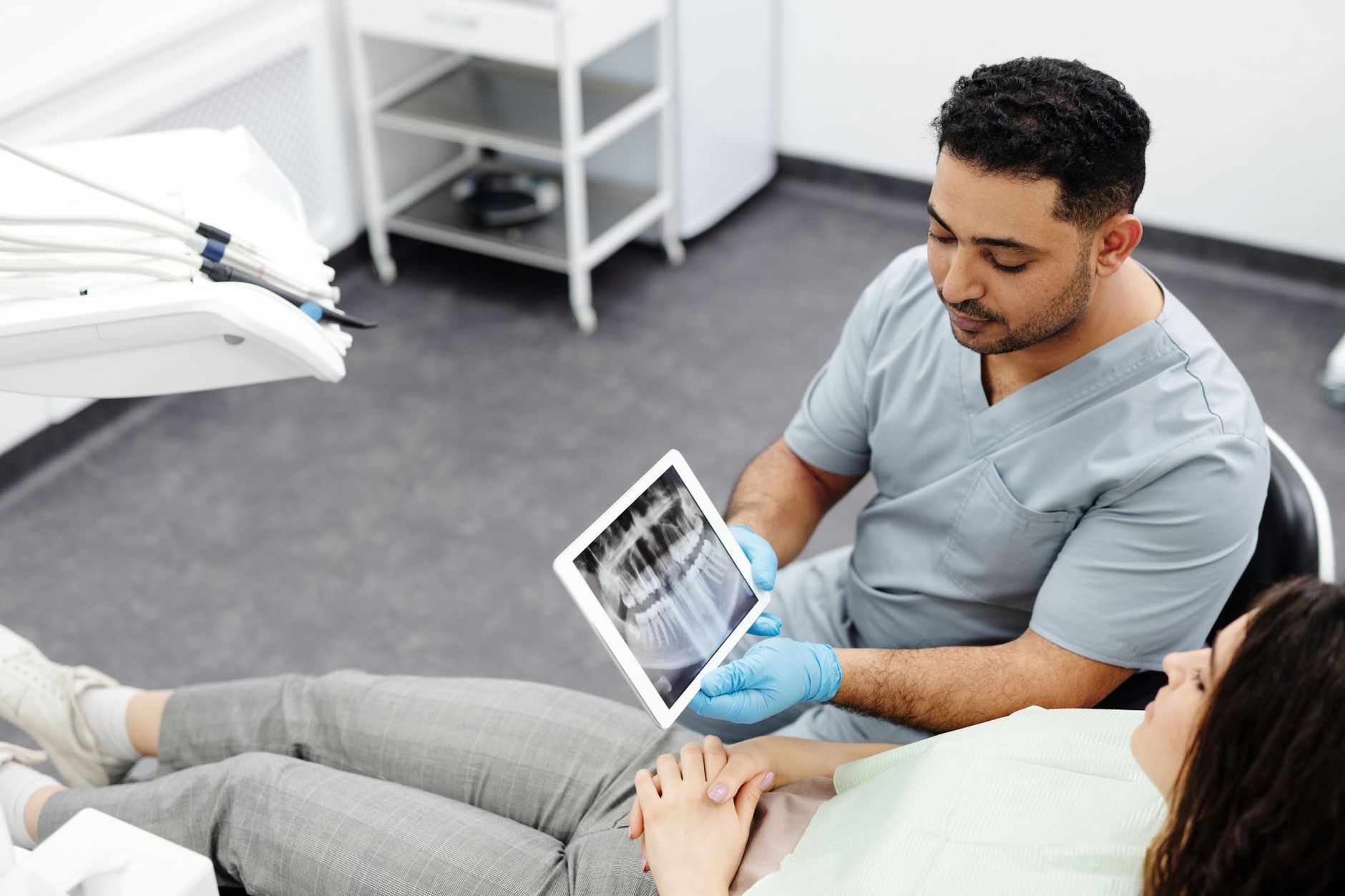 Consulta odontológica moderna donde un dentista explica un tratamiento a su paciente