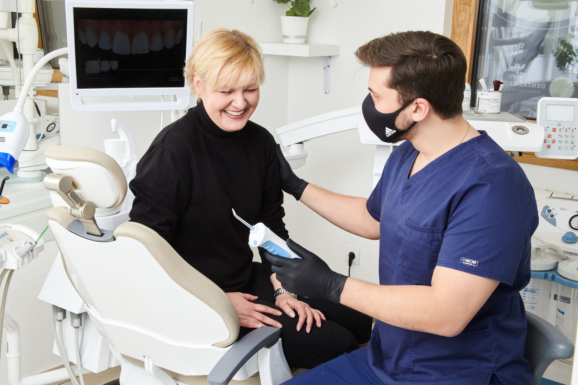 Dentista y paciente revisando juntos un presupuesto de tratamiento dental en la consulta