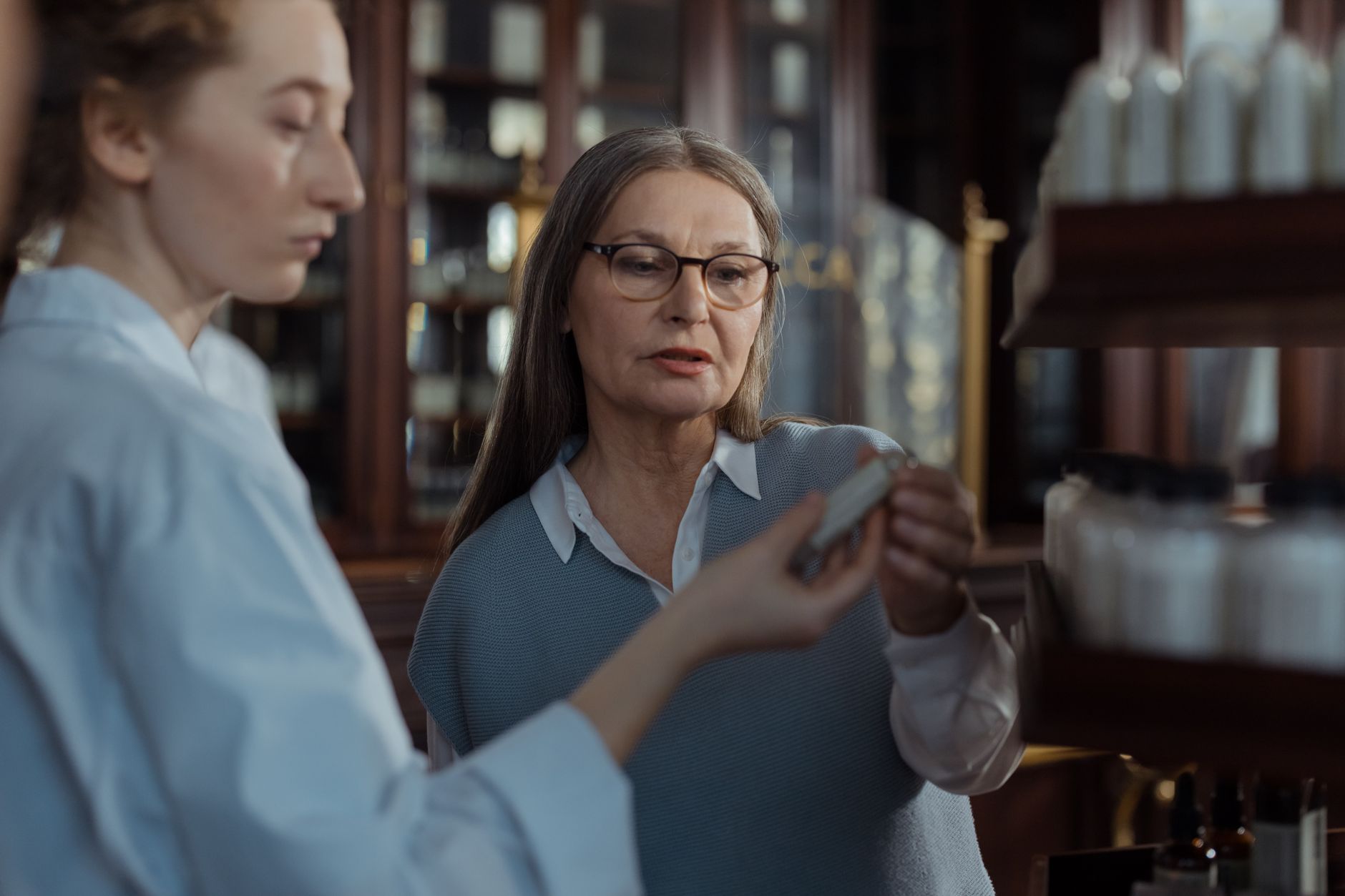 Farmacéutico atendiendo a un cliente en el mostrador de una farmacia