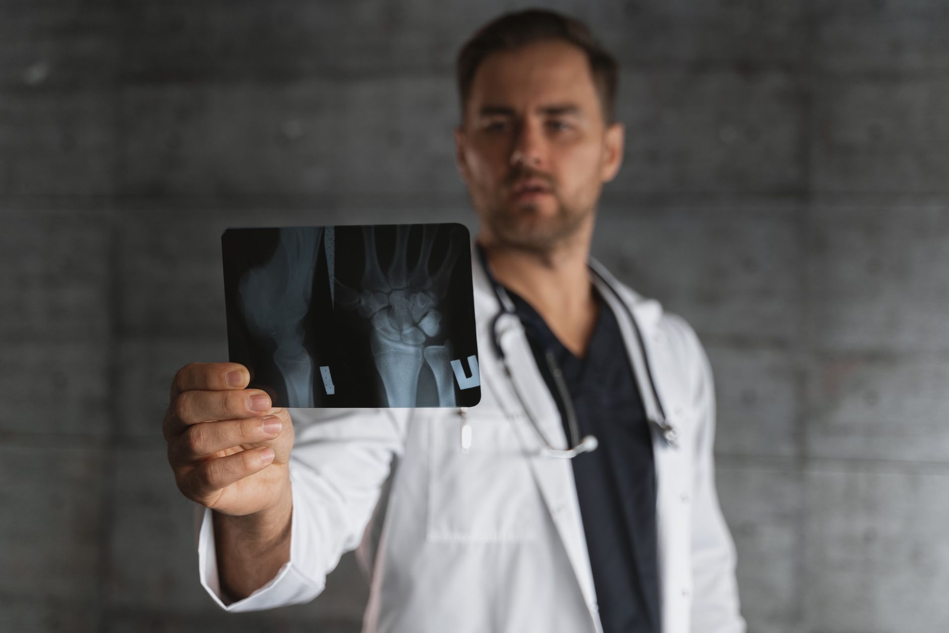 Traumatólogo examinando radiografía de rodilla con el paciente